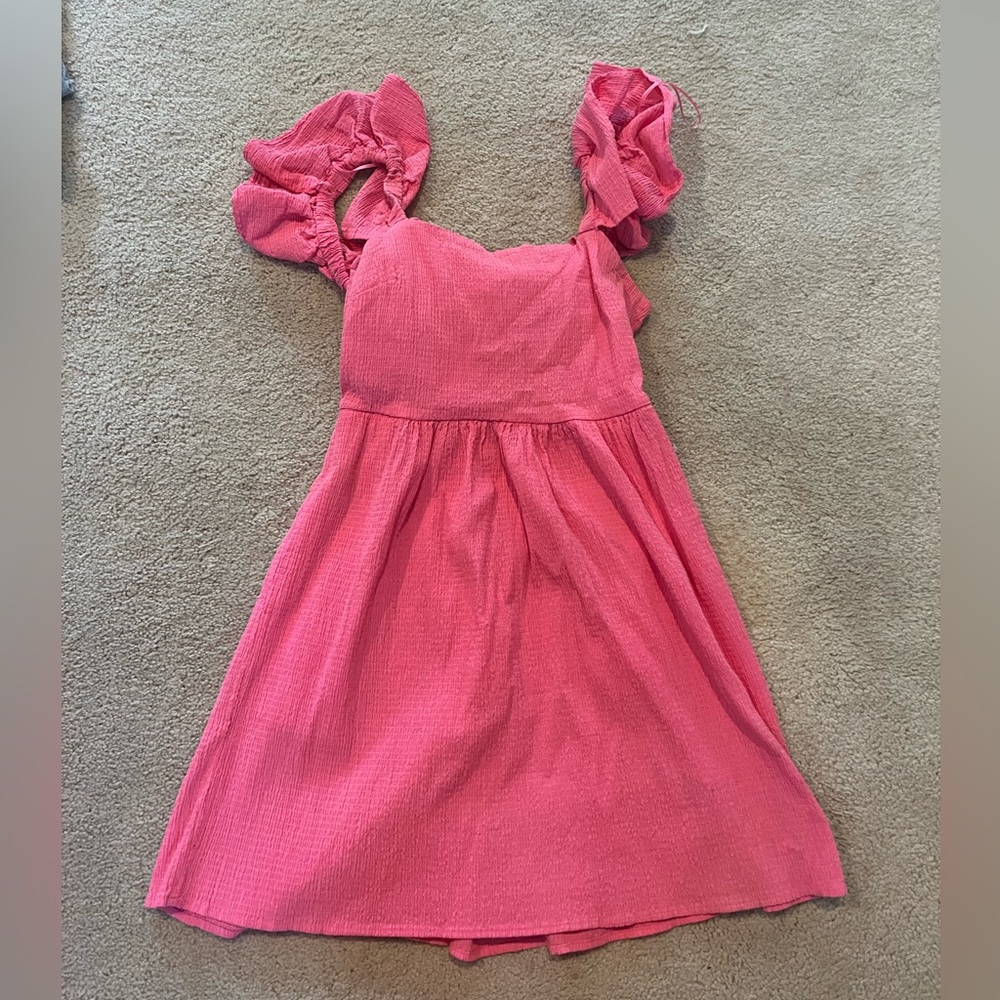 Hot pink mini dress with ruffles on the sleeve and an open back with a tie